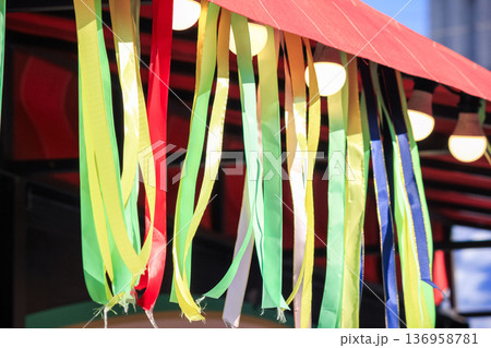 Spring festival canopy decorated with vibrant colorful ribbons and warm glowing light bulbs. 136958781