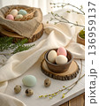 Pastel eggs placed on a soft linen fabric with a natural texture. In a minimalist rustic modern style with warm daylight 136959137