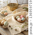 Pastel eggs placed on a soft linen fabric with a natural texture. In a minimalist rustic modern style with warm daylight 136959719