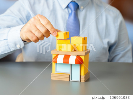 A man stacks boxes at a store. Delivering goods and replenishing inventory for retail establishments. Supply chain logistics and warehouse management 136961088