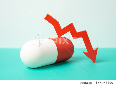 Medicinal capsule and red arrow pointing down. Decreasing drug effectiveness and limited popularity. Antibiotics shortage and supply decline. Pharmaceutical market crisis and resistance problem 136961159