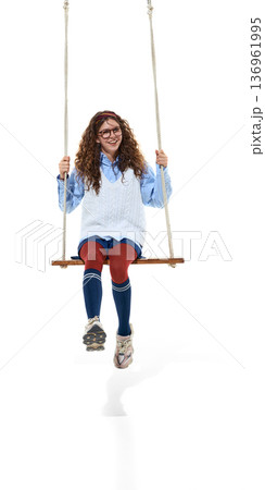 Teenage girl sitting on swing smiling isolated on white. Teenage girl sitting on swing smiling isolated on white. 136961995