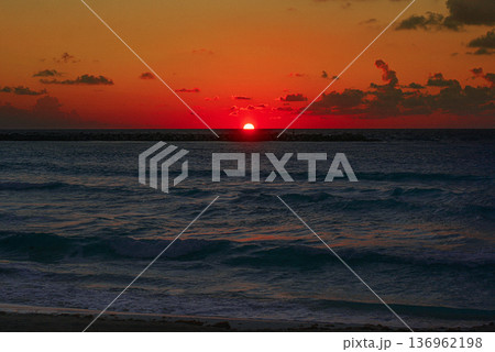Intense red mexican sunset over dark ocean waves 136962198