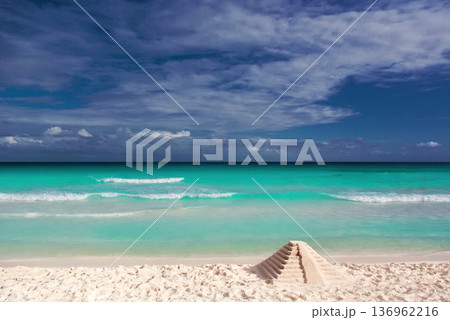 Sand pyramid on pristine mexican beach with turquoise sea Sand pyramid on pristine mexican beach with turquoise sea 136962216