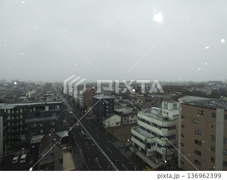 雪が降る冬の街並みと幹線道路を見下ろす俯瞰風景 136962399