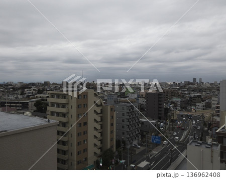 曇天の空の下に広がる都市の街並みと道路 136962408