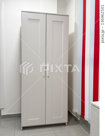 White wardrobe cabinet in modern minimalist interior. Storage solution, organization concept, home furniture design, clean aesthetic space 136962501