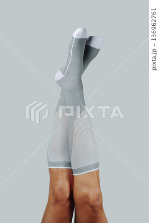 gray compression socks on upside down legs 136962761