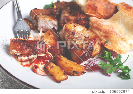 A plate with the remains of a pork kebab, there are no people. 136962974