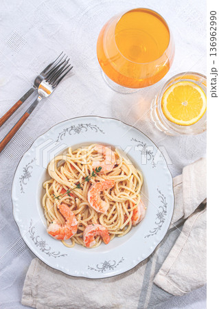 Pasta with shrimp and thyme, served on a white plate, with a glass of white wine, the table is set, there are no people, Pasta with shrimp and thyme, served on a white plate, with a glass of white wine, the table is set, there are no people, 136962990