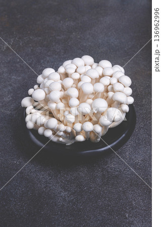 fresh white shimeji mushrooms, on a black plate, no people. 136962996