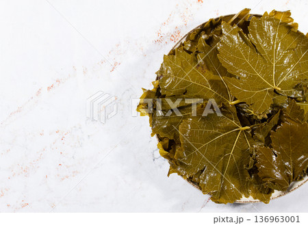 canned grape leaves, for cooking dolma, on a plate, 136963001