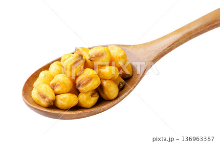 Roasted corn seeds in a wooden spoon on a white background. Isolated 136963387