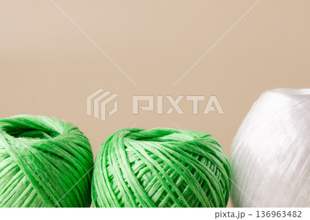 Balls of recycled polyester synthetic thread in various colors on beige background. Eco-friendly living, plastic recycling, reuse 136963482