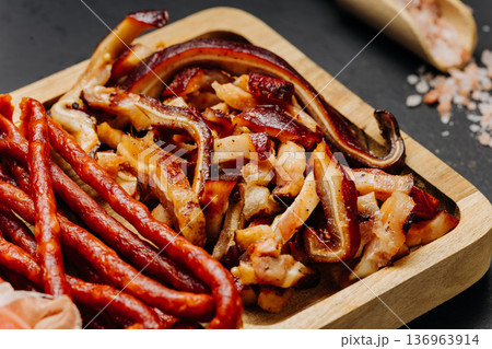 Closeup of cured meats and smoked sausages on wooden board gourmet snack assortment Closeup of cured meats and smoked sausages on wooden board gourmet snack assortment 136963914