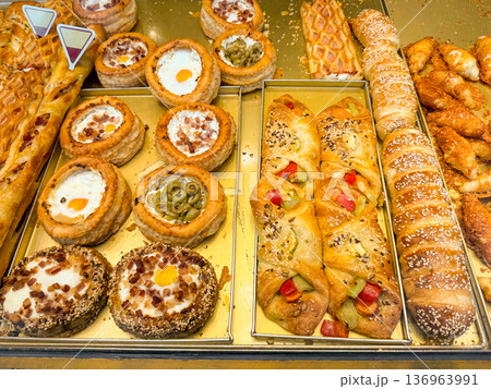Close up of savory pastry with egg and bacon in bakery case. Breakfast option, street snack, comfort food, culinary craftsmanship, gastronomy tradition Close up of savory pastry with egg and bacon in bakery case. Breakfast option, street snack, comfort food, culinary craftsmanship, gastronomy tradition 136963991