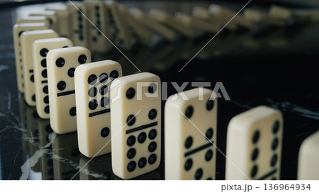 Falling domino pieces trigger a continuous chain reaction. Symbol of cause and effect Falling domino pieces trigger a continuous chain reaction. Symbol of cause and effect 136964934