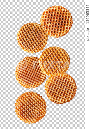 Multiple round caramel stroopwafels arranged in a scattered pattern from above, on a white background. Concept of sweet snacks 136965555