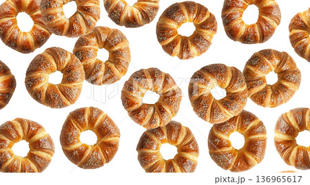 Multiple twisted pretzel buns or bagel with coarse salt topping arranged in seamless pattern isolated on white background 136965617