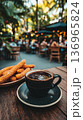 Lively city cafe scene featuring churros and warm drinks at dusk 136965824