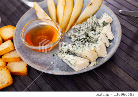 Pieces of blue cheese served on wooden table 136966588