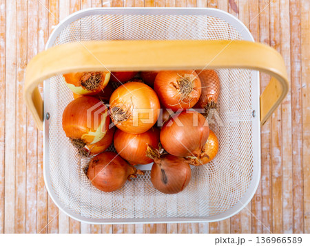 Yellow onion in basket on wooden table Yellow onion in basket on wooden table 136966589