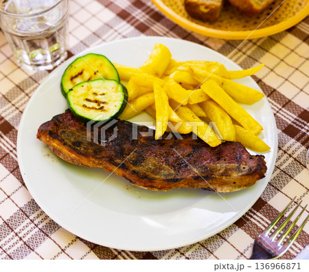Traditional Spanish dish is Churasco with French fries and zucchini Traditional Spanish dish is Churasco with French fries and zucchini 136966871