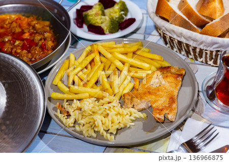 Turkish chicken chop with fried potatoes and fusilli Turkish chicken chop with fried potatoes and fusilli 136966875