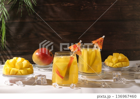Frozen lemonade or juice with mango slices, mojito with tequila, lemon, and ice, bar and party concept, restaurant and cafe advertising card, restaurant menu, house party advertising banner Frozen lemonade or juice with mango slices, mojito with tequila, lemon, and ice, bar and party concept, restaurant and cafe advertising card, restaurant menu, house party advertising banner 136967460
