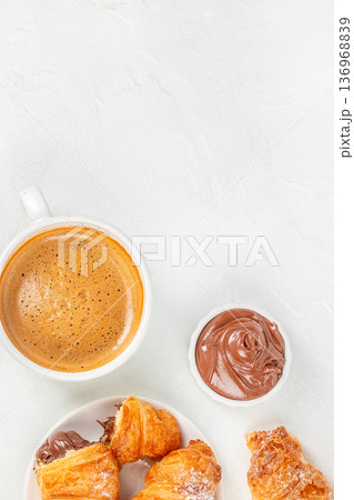Chocolate croissants with coffee and chocolate spread on white background 136968839