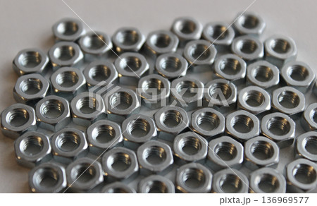 Steel Screw Nuts Laid Out On White Surface Texture Background Steel Screw Nuts Laid Out On White Surface Texture Background 136969577
