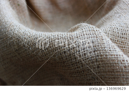 Pattern of wavy folds of large weave burlap fabric stock photo for backgrounds. Selective and partial focus burlap background Pattern of wavy folds of large weave burlap fabric stock photo for backgrounds. Selective and partial focus burlap background 136969629