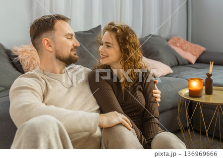 Happy couple cuddling on sofa at home romantic evening lifestyle Happy couple cuddling on sofa at home romantic evening lifestyle 136969666