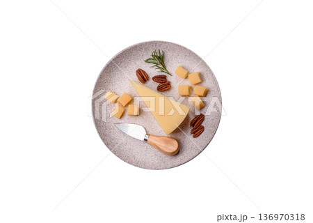 A wedge of cheddar, gouda, or parmesan cheese on a cutting board. Cheese wedge 136970318