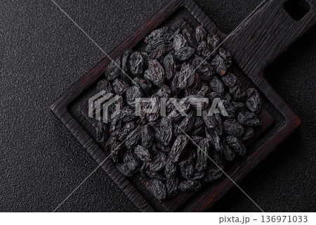 Sweet, dry black or blue raisins made from grapes are a healthy and nutritious food. Black raisins Sweet, dry black or blue raisins made from grapes are a healthy and nutritious food. Black raisins 136971033