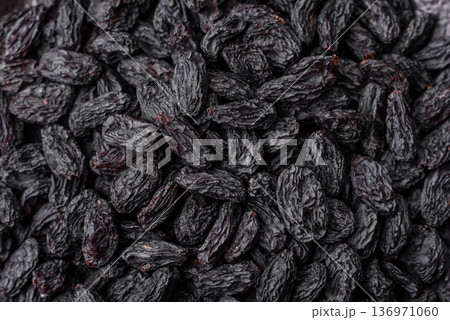 Sweet, dry black or blue raisins made from grapes are a healthy and nutritious food. Black raisins Sweet, dry black or blue raisins made from grapes are a healthy and nutritious food. Black raisins 136971060