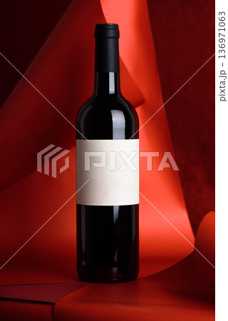 Red Wine Bottle on Red Background. Elegant Festive Still Life Red Wine Bottle on Red Background. Elegant Festive Still Life 136971063