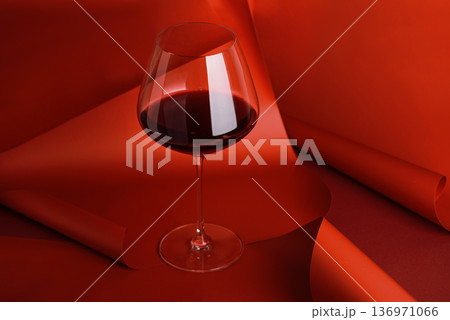 Red Wine Glass on Sculptural Red Background. Elegant Monochrome Still Life Red Wine Glass on Sculptural Red Background. Elegant Monochrome Still Life 136971066
