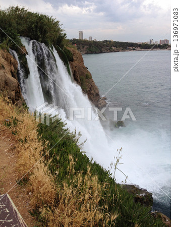 Duden Waterfall crashes down rocky cliff near city in Turkey in the province of Antalya . Force, motion, gravity, solitude, erosion, time, connection, awe, freedom, and escape from urban routine 136971083