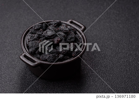 Sweet, dry black or blue raisins made from grapes are a healthy and nutritious food. Black raisins Sweet, dry black or blue raisins made from grapes are a healthy and nutritious food. Black raisins 136971180