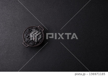 Sweet, dry black or blue raisins made from grapes are a healthy and nutritious food. Black raisins Sweet, dry black or blue raisins made from grapes are a healthy and nutritious food. Black raisins 136971185