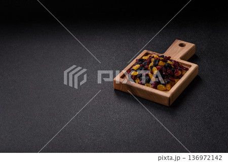 Dried cranberries, yellow and black sweet raisins as ingredients for a breakfast. Raisins and cranberries Dried cranberries, yellow and black sweet raisins as ingredients for a breakfast. Raisins and cranberries 136972142