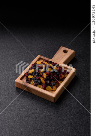 Dried cranberries, yellow and black sweet raisins as ingredients for a breakfast. Raisins and cranberries 136972145