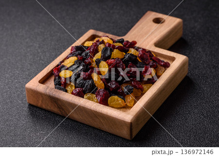 Dried cranberries, yellow and black sweet raisins as ingredients for a breakfast. Raisins and cranberries Dried cranberries, yellow and black sweet raisins as ingredients for a breakfast. Raisins and cranberries 136972146