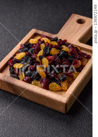 Dried cranberries, yellow and black sweet raisins as ingredients for a breakfast. Raisins and cranberries Dried cranberries, yellow and black sweet raisins as ingredients for a breakfast. Raisins and cranberries 136972149