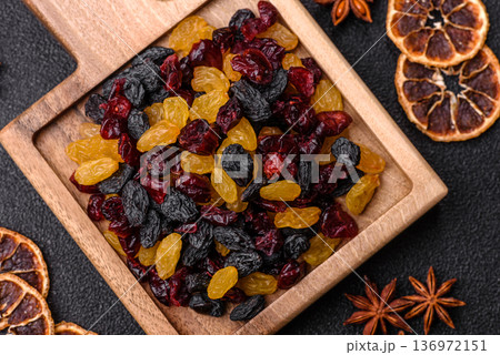 Dried cranberries, yellow and black sweet raisins as ingredients for a breakfast. Raisins and cranberries Dried cranberries, yellow and black sweet raisins as ingredients for a breakfast. Raisins and cranberries 136972151