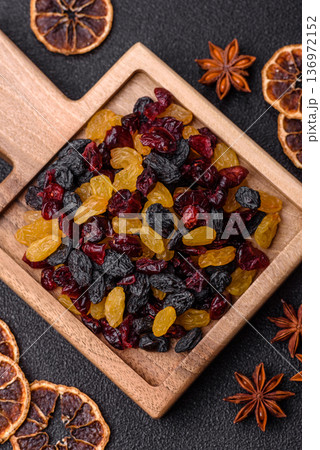 Dried cranberries, yellow and black sweet raisins as ingredients for a breakfast. Raisins and cranberries Dried cranberries, yellow and black sweet raisins as ingredients for a breakfast. Raisins and cranberries 136972152
