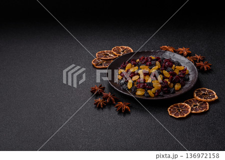Dried cranberries, yellow and black sweet raisins as ingredients for a breakfast. Raisins and cranberries 136972158