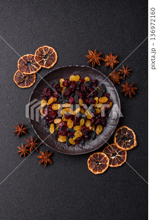 Dried cranberries, yellow and black sweet raisins as ingredients for a breakfast. Raisins and cranberries 136972160