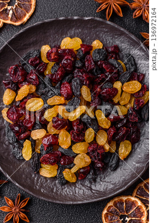 Dried cranberries, yellow and black sweet raisins as ingredients for a breakfast. Raisins and cranberries Dried cranberries, yellow and black sweet raisins as ingredients for a breakfast. Raisins and cranberries 136972164